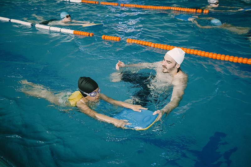 Trener uczy pływać młodą osobę